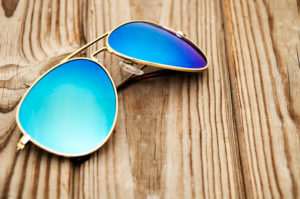 Aviator Sunglasses sitting on a wooden table.
