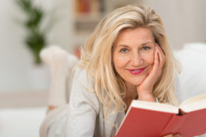 Woman smiling and reading after Cataract Surgery