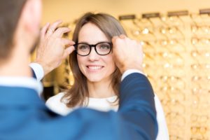 Person getting glasses fitted to their face. There are no glasses inside the glasses frames.