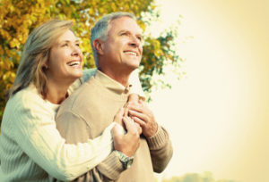 Happy couple against a fall backdrop.