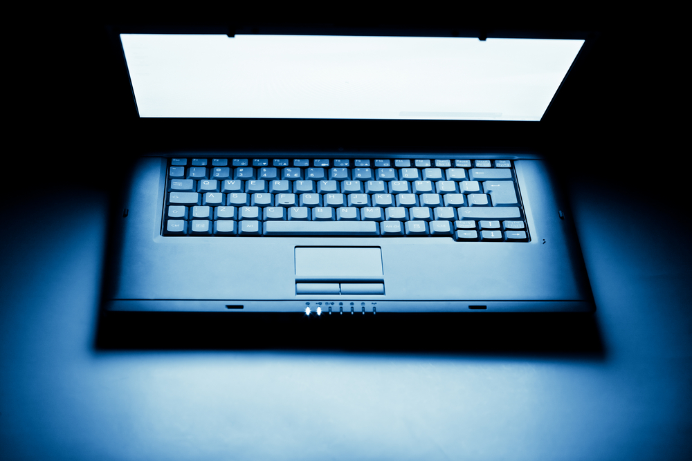 Half Open Laptop with its bright screen illuminating the keys.