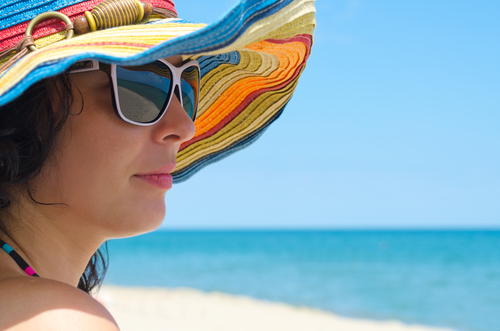 Close up portrait of a fashionable person against a beach backdrop.