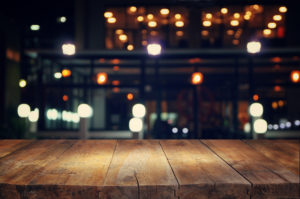 Wooden Table, with out of focus lights in the distance giving way to circular bokeh
