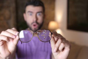 Man holding broken glasses